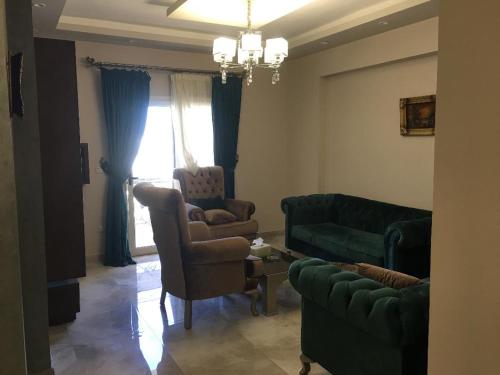 a living room with a couch and a chair at Ramco For Furnished Apartments And Accommodation Compound Leila in Cairo