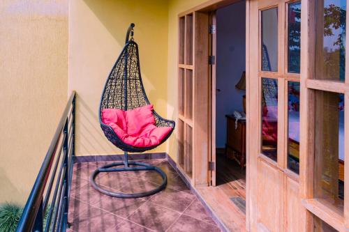 a hammock chair sitting on the balcony of a house at Fort Fun City Hotel Fort Portal in Fort Portal
