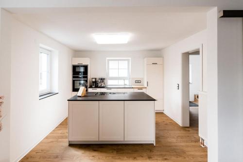 a kitchen with white cabinets and a black counter top at Rosenchalet in Leinach