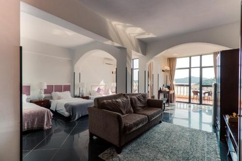 um quarto com uma cama, um sofá e uma cama em Pousada de Coloane Boutique Hotel em Macau
