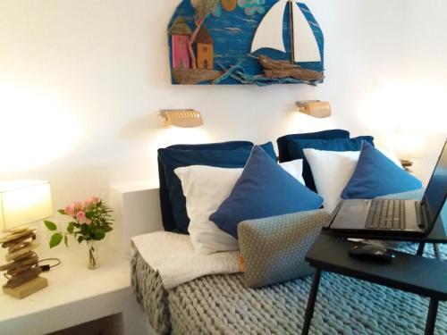 a living room with a couch with blue pillows and a laptop at Anofli Suites in Skopelos Town