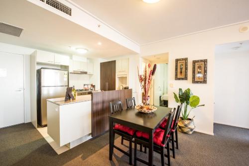 a kitchen and dining room with a table and chairs at African Sky Retreat - Level 38 CBD Apartment with River Views in Brisbane