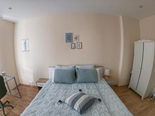 a bedroom with a large bed with blue pillows at By the CATHEDRAL · TOP center · 2 Bedroom FLAT in Varna City
