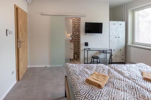 a bedroom with a bed and a table and a window at Penzion Moon in Ostrava