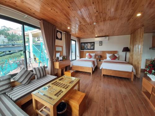a hotel room with two beds and a couch at SaPa Retreat Condotel in Sa Pa