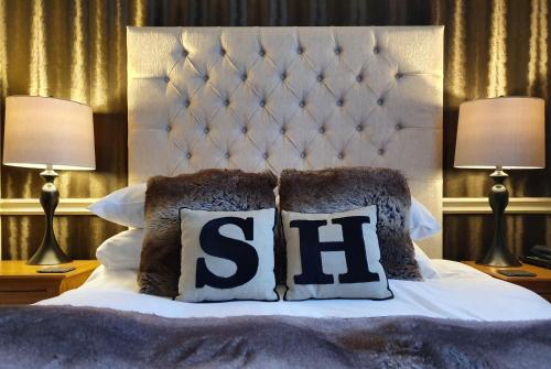 a bed with two lamps and two pillows on it at Sawrey House in Near Sawrey