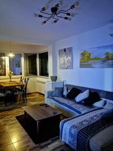 a living room with a couch and a table at Apartman EDEN No 1 in Teslić