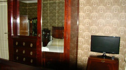 CASA RURAL PIEDRAHÍTA ( ART DÉCO ) في بيدراهيتا: غرفة نوم مع مرآة وتلفزيون وخزانة