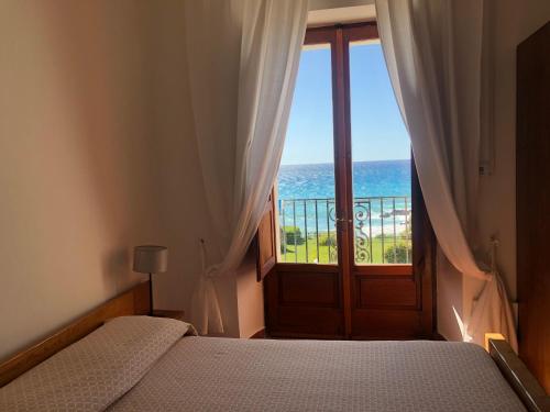 a bedroom with a bed and a view of the ocean at Hotel Palazzo Ducale in Diamante