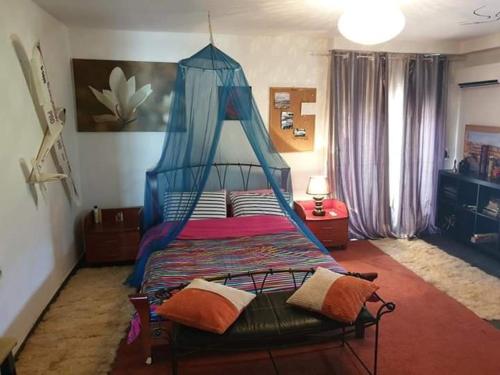 1 dormitorio con 1 cama con dosel azul en Rural hοuse en Kastrítsa