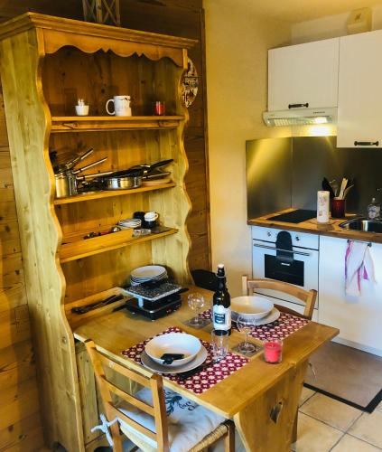 une cuisine avec une table en bois et des plaques de cuisson. dans l'établissement Charmant studio Mont Dore, à Le Mont-Dore