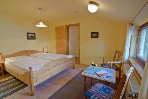 - une chambre avec un grand lit et une table dans l'établissement Haus Mittagsruh-Göhren, à Göhren