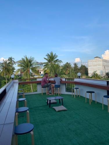 two people sitting on the roof of a building at Sleepbox Hostel Suratthani in Suratthani