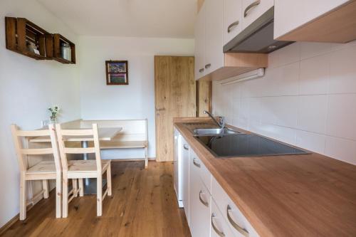 a kitchen with a sink and a table with a chair at Innertrein in Cadipietra