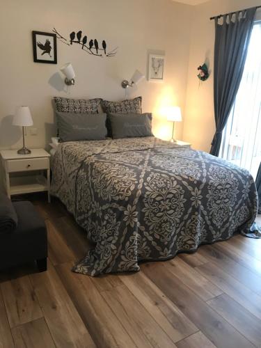 1 dormitorio con 1 cama y suelo de madera en Sigga’s home, en Hveragerði