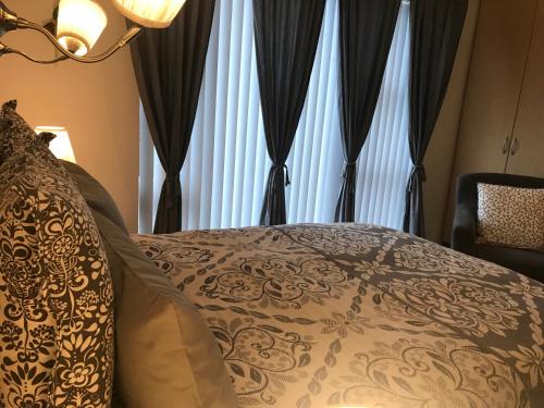 um quarto com uma cama e uma janela com cortinas em Sigga’s home em Hveragerði