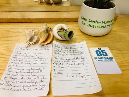 a desk with two sheets of paper with writing on it at Coto Center Homestay in Dao Co To