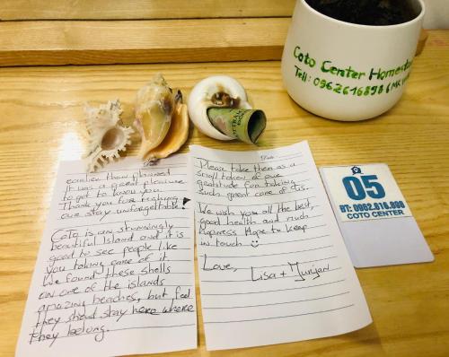 a note and a cup of coffee and some fruit at Coto Center Homestay in Dao Co To