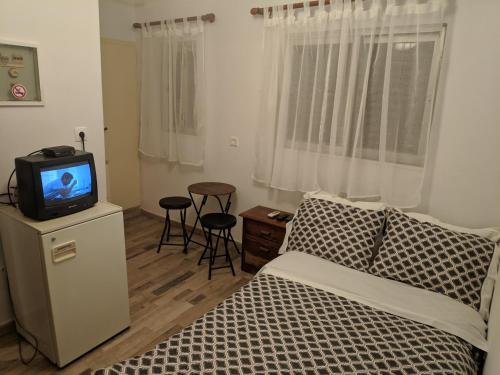 sypialnia z łóżkiem i telewizorem na szafce w obiekcie Sky line center city Dimitropoulos w mieście Ejo