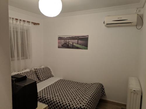 a bedroom with a bed and a air conditioner at Sky line center city F in Aígio