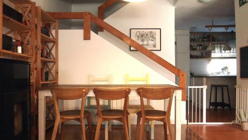 a kitchen with a bar with four chairs around it at Casa Azahar in Villalba de la Sierra