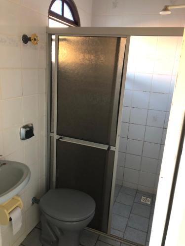 a bathroom with a shower with a toilet and a sink at Pícoli e De Angelis- Casa de praia em Piuma com WI-FI in Piúma