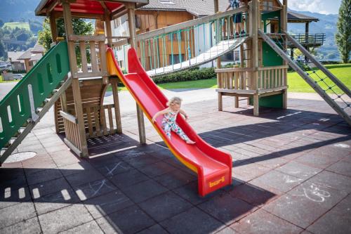 a young child on a slide at a playground at Marina Walensee Hotel in Unterterzen
