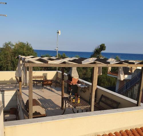 an outdoor deck with a pergola and tables and chairs at Villa Capriccio in Villaggio San Leonardo