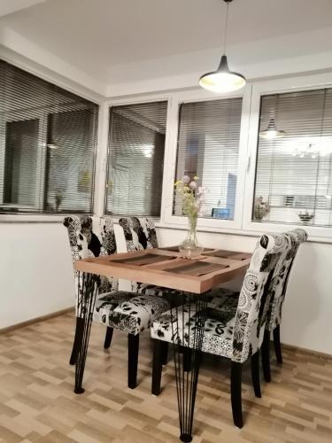 a dining room with a wooden table and chairs at Apartman EDEN No 1 in Teslić