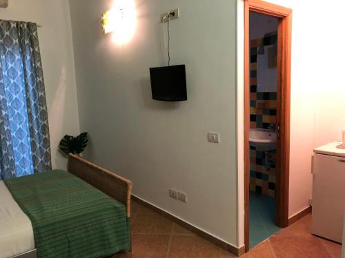 a small room with a bed and a tv on the wall at FOUR SEASONS in Nicolosi
