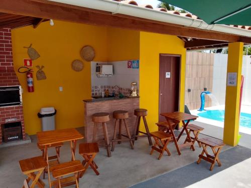 a patio with tables and chairs and a swimming pool at Pousada Chalés do Toque in São Miguel dos Milagres