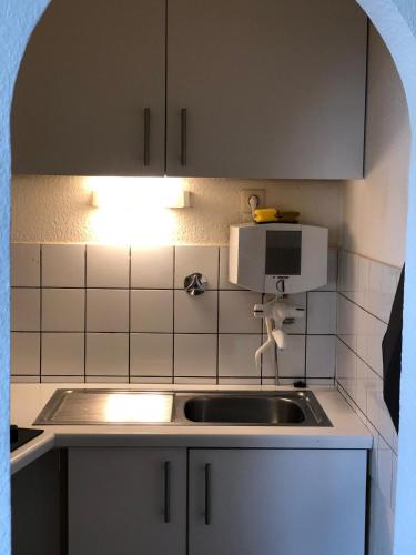 a kitchen with a sink and a microwave at Altstadt Kurzestr in Düsseldorf