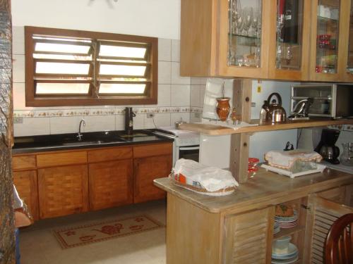 a kitchen with wooden cabinets and a counter top at Linda casa Boicucanga in São Sebastião