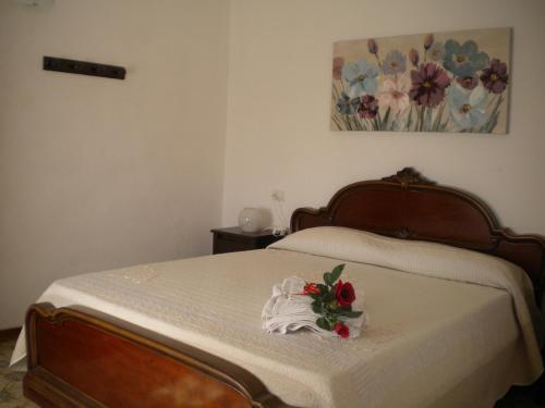 a bedroom with a bed with a bouquet of flowers on it at casetta del nonno bis in Arcola