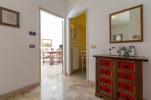 a room with a dresser and a mirror and a table at Mamma Ciccia Holiday Home - Lake Front Apartment in Mandello del Lario