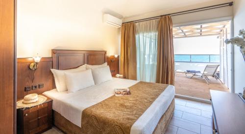 a hotel room with a bed and a balcony at Paralia Beach Boutique Hotel in Paralia Katerinis