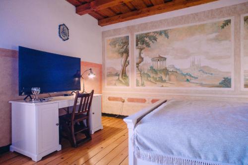 a bedroom with a bed and a desk with a monitor at Vila Terrasse in Košice