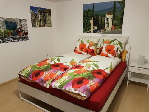 a bedroom with a bed with a floral comforter at Ferienwohnung keine Monteurvermietung Nähe Heidelberg Hockenheim BDS Anlage in Philippsburg