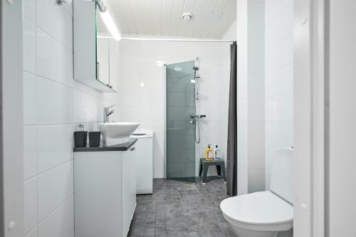 a white bathroom with a sink and a toilet at Apartments in Porvoo in Porvoo