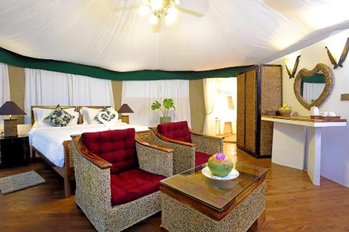 a bedroom with a bed and chairs and a table at Canvas & Orchids Retreat in Tatai