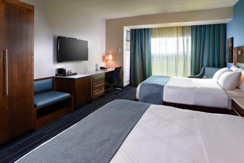 Habitación de hotel con cama, escritorio y TV. en Tioga Downs Casino and Resort en Nichols