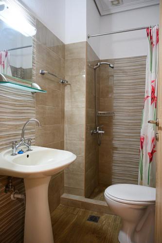 a bathroom with a sink and a toilet and a shower at Anastasios Room's in Olympiaki Akti