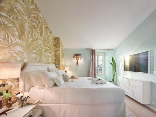 - une chambre avec un lit blanc et une fresque murale dans l'établissement Maison Panthère - Luxury Harbour Residence, à Saint-Tropez