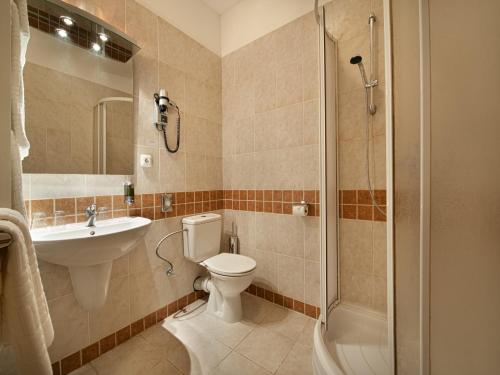 a bathroom with a toilet and a sink and a shower at EA Hotel Tosca in Prague