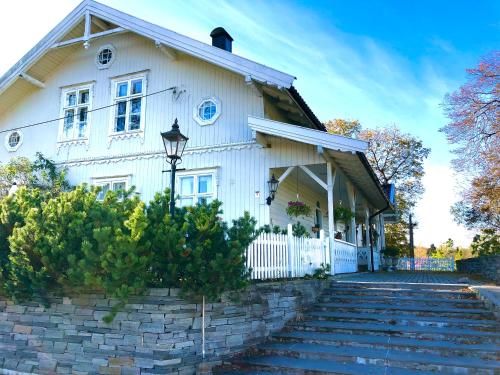 una casa blanca con una valla blanca y escaleras en Gjedsjø Gaard, en Ski