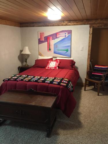 a bedroom with a red bed and a painting on the wall at The Old Church B&B in Warner