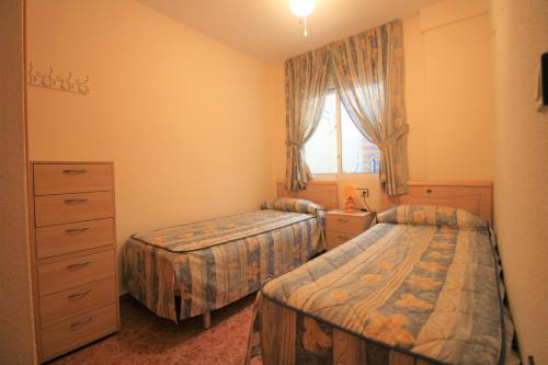 グラン・アラカントにあるApartamento CasaTuris Urb.Altomar Gran Alacant GA101のベッドルーム1室(ベッド2台、ドレッサー、窓付)