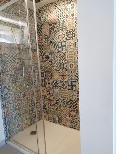 a shower with a glass door and a tiled wall at Wine Loft 66 in Baixas