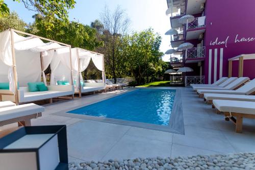 a swimming pool with chaise lounge chairs next to a building at Ideal House in Parga