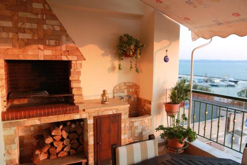 a patio with a brick fireplace with a table and a balcony at Apartment with marina view in Thessaloniki